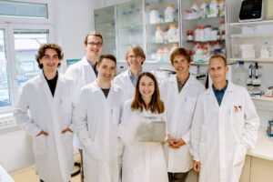 7 Kollegen im Labor in Laborkitteln